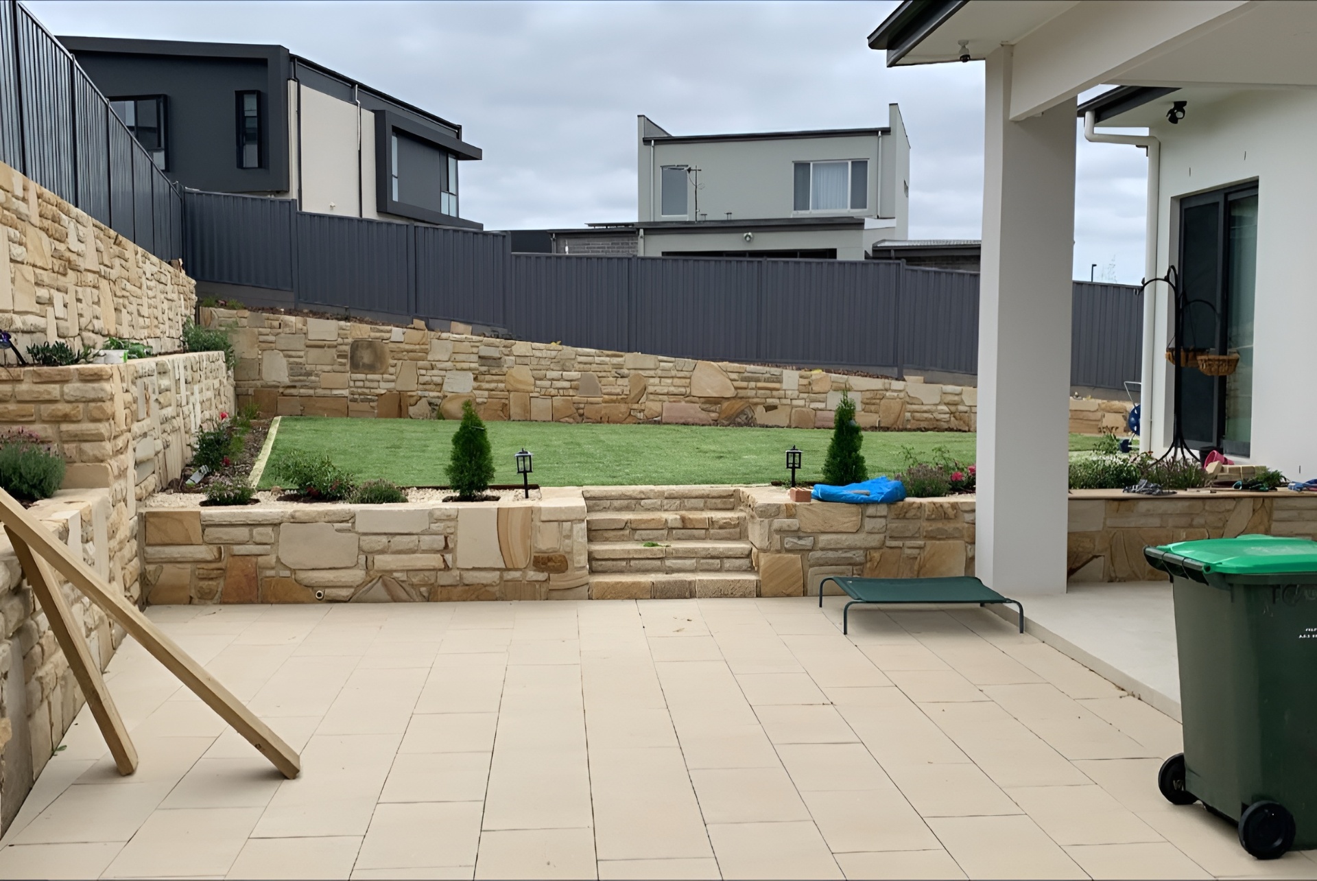 Landscaped Canberra backyard with stone retaining walls and lawn